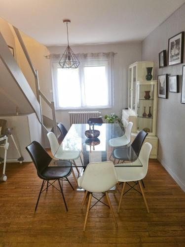une salle à manger avec une table et des chaises dans l'établissement Maison spacieuse avec jardin et salle de sport, à Saint-Brieuc