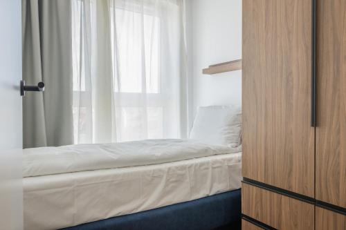 a bedroom with a bed and a window at Noli Gdansk Wrzeszcz in Gdańsk