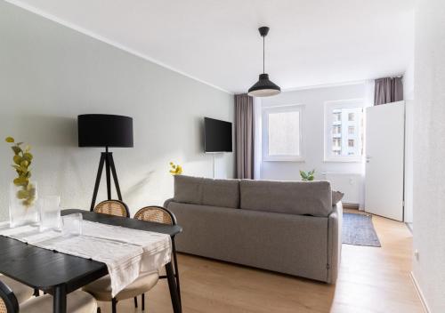 a living room with a couch and a table at Limehome Magdeburg Breiter Weg in Magdeburg