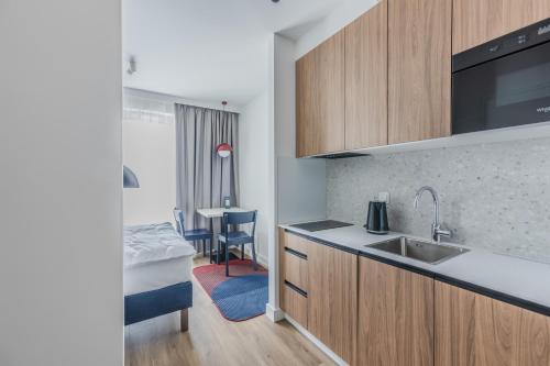 a kitchen with a sink and a bed in a room at Noli Gdansk Wrzeszcz in Gdańsk