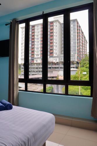 a bedroom with a view of a city through a window at Hotel Aaraa in Brinchang