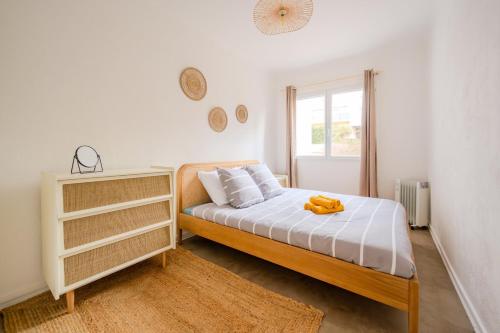 une chambre blanche avec un lit et une fenêtre dans l'établissement Le Cocon du Mourillon, à Toulon