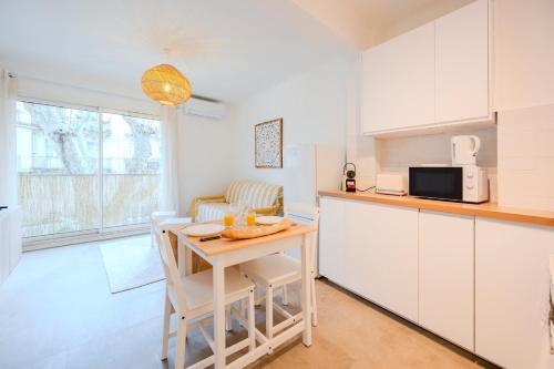 une cuisine avec une petite table et un micro-ondes dans l'établissement Le Cocon du Mourillon, à Toulon