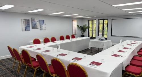 a meeting room with white tables and red chairs at Europa Gatwick Hotel & Spa in Crawley