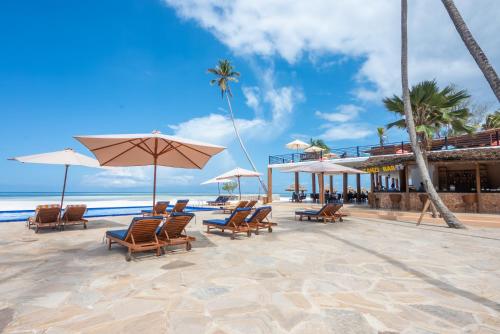 a group of chairs and umbrellas on a beach at Royal Mandarin Hotel & Resort in Pwani Mchangani