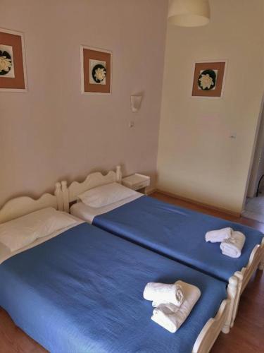 a bedroom with two beds with blue sheets and towels at Firefly Studios Christos 14 in Moraitika