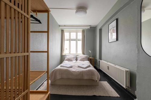 une petite chambre avec un lit et une fenêtre dans l'établissement 2 BR Apartment in Heart of Vesterbro, à Copenhague