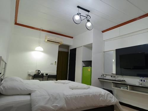 a bedroom with a large bed and a television at Hotel Paraiso in Bangkok