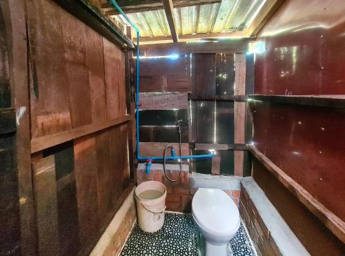 a small bathroom with a toilet and a bucket at Ratanakiri Homestay & Jungle Trek in Banlung