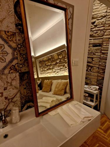 a mirror on top of a sink in a bathroom at My Home Assisi in Assisi
