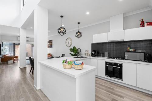 a kitchen with white cabinets and a white counter top at Peaceful gem near Town Centre in Point Cook