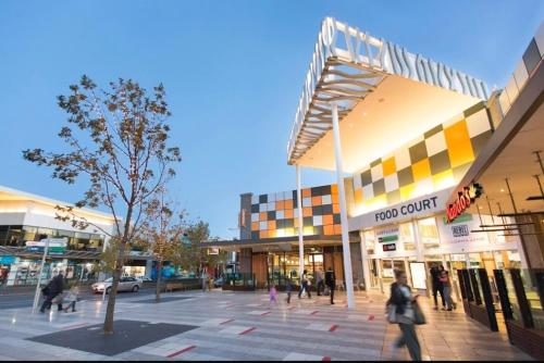 a group of people walking around a shopping center at Peaceful gem near Town Centre in Point Cook