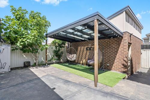 a pavilion with two chairs and grass in a backyard at Peaceful gem near Town Centre in Point Cook