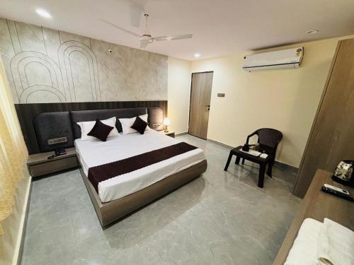 a bedroom with a large bed and a chair at Hotel Supreme Stay in Jodhpur