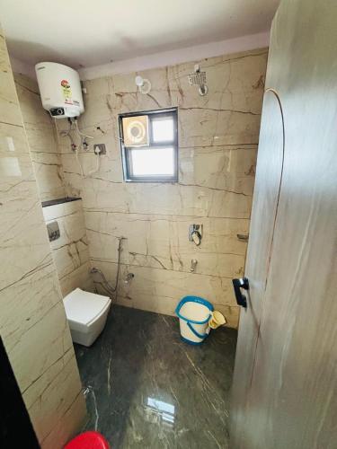 a bathroom with a toilet and a window at Hotel Supreme Stay in Jodhpur