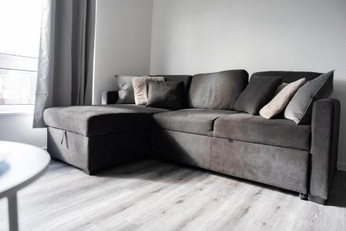 un divano grigio in un soggiorno con tavolo di Renfrew House a Renfrew