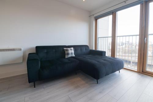 a black couch in a room with a large window at Argyle Place in Glasgow