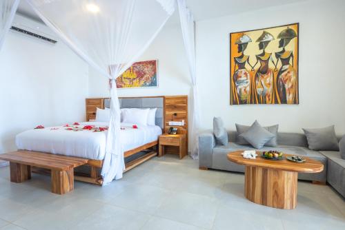 a bedroom with a bed and a couch at Royal Mandarin Hotel & Resort in Pwani Mchangani