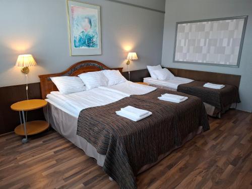 a hotel room with two beds with towels on them at Hotel Lapuahovi in Lapua