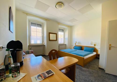 a small room with a bed and a table at Landgasthof Goldener Löwe Mainbernheim in Mainbernheim