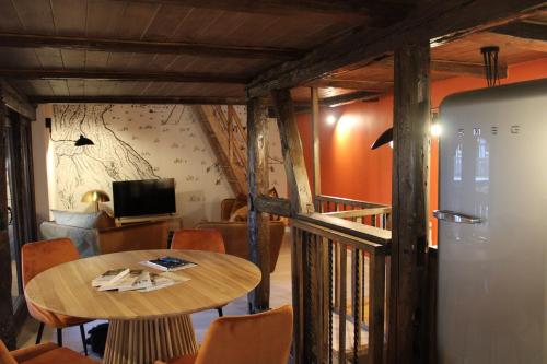a dining room with a table and a refrigerator at Les Gîtes de la Billebaude - Gîte du Renard in Eckwersheim