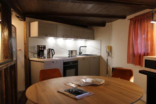 a kitchen with a wooden table with chairs and a table and a table at Les Gîtes de la Billebaude - Gîte du Renard in Eckwersheim