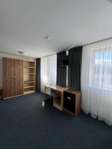 an empty room with a desk and a window at Sport hotel Sletiště in Kladno