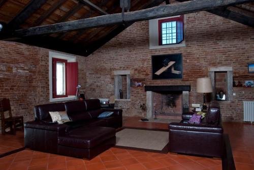 a living room with leather furniture and a brick wall at Quinta da Gafaria in Santarém