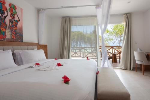a bedroom with a bed with red roses on it at Royal Mandarin Hotel & Resort in Pwani Mchangani