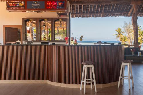 a bar with two stools in front of it at Royal Mandarin Hotel & Resort in Pwani Mchangani