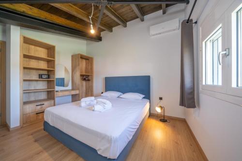 a bedroom with a large bed with white sheets at Pecora Nera apartments in Lixouri