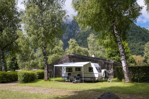 a campsite with a tent and a table and chairs at Camping RCN Belledonne in Le Bourg-dʼOisans