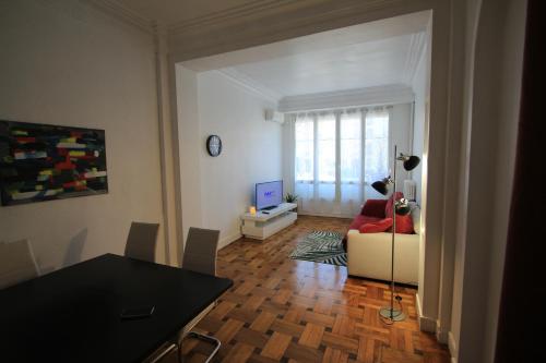 una sala de estar con una mesa y un sofá en LE REX Nice, en Niza
