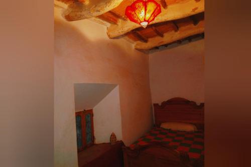 a bedroom with a bed and a ceiling with a light at Kasbah Alami in Kalaat MGouna