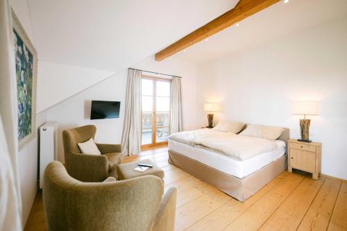 a bedroom with a bed and two chairs at Forthuber Landhaus - Self Check-in möglich in Feldkirchen bei Mattighofen