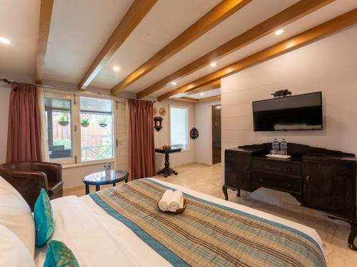a hotel room with a bed and a flat screen tv at Moustache Mussoorie in Mussoorie