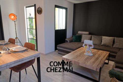 un salon avec une table et un canapé dans l'établissement Suite Le Loft And Garden & Spa, à Nancy