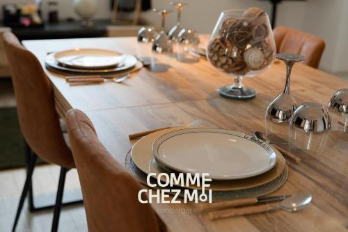 une table en bois avec des assiettes et des verres dans l'établissement Suite Le Loft And Garden & Spa, à Nancy