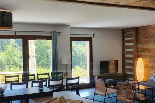 un salon avec des chaises, des tables et des fenêtres dans l'établissement 3 apartment with terrace and 3 bedrooms, à Saint-Jean-de-Sixt