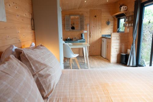 a bedroom with a bed and a kitchen in a cabin at De Zilte Zeehoeve in Ellemeet