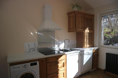 a kitchen with a sink and a washing machine at L'orée de la Roche in Poule-lès-Écharmeaux