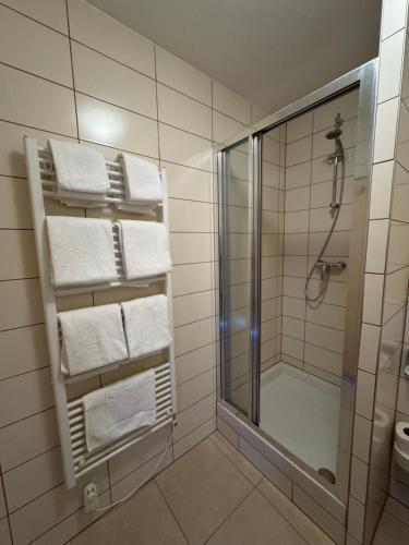 a bathroom with a shower and white towels at Sport hotel Sletiště in Kladno