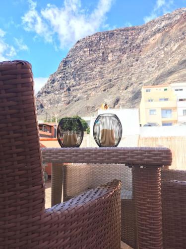 a table with two chairs and a view of a mountain at Große Dachwohnung mit Blick auf das Meer in Valle Gran Rey
