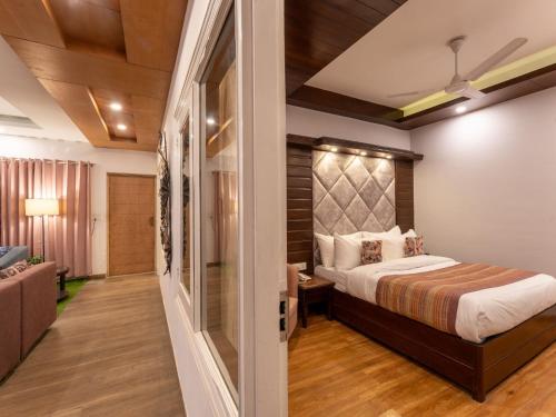 a bedroom with a bed and a living room at Moustache Mussoorie in Mussoorie