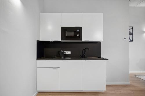 a white kitchen with a microwave and a sink at Imperiashortstay in Zaventem
