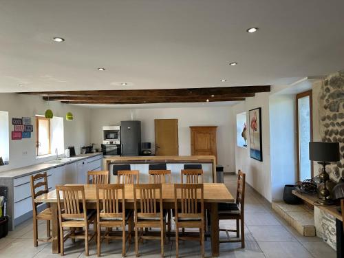 une cuisine et une salle à manger avec une table et des chaises en bois dans l'établissement Les coqs de Mirebois ,Maison de campagne de 200 M2 pour 10 Personnes, à Bas-Mollard