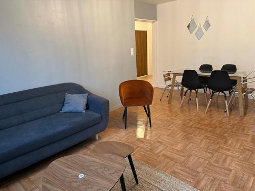 a living room with a couch and a table and chairs at Appart proche gare et Auxerrexpo in Auxerre