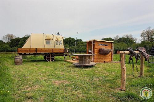 a truck and a trailer and a shed in a field at La caleche de kergomar in Ploumilliau