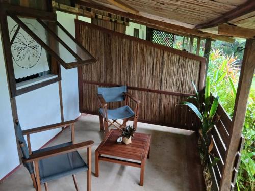 a porch with two chairs and a table at Boraha Village Ecolodge in Sainte Marie