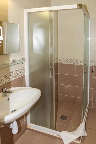a bathroom with a shower and a sink at Land-Plan Hotel in Töltéstava